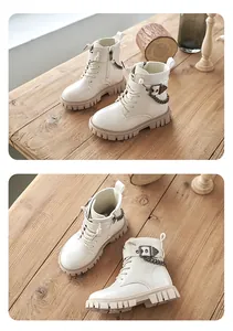 Detailansicht cremefarbener Kinder-Martin-Stiefel im britischen Stil auf Holztisch