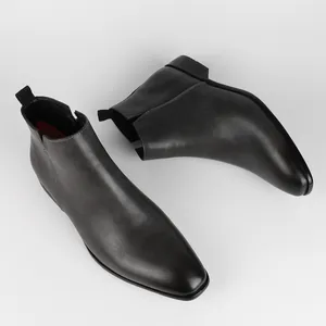 Dettaglio degli eleganti stivali Chelsea da uomo in pelle nera con punta quadrata