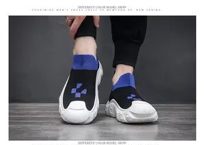 Close-up of men's black fly-knit sock sneakers with blue accents and white thick soles.