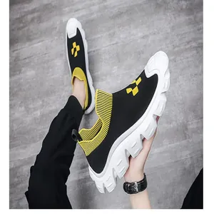 Detail view of men's fly-knit sock shoes with yellow checkered pattern and chunky sole