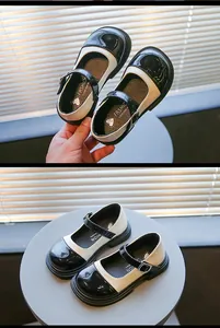 Close-up of retro color-blocked girls Mary Jane shoes with black and beige patent leather