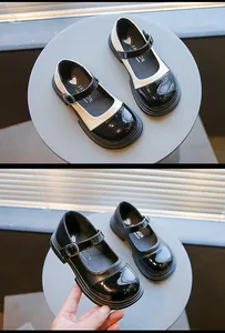 Detailed view of girls' black and white Mary Jane shoes with glossy patent leather finish