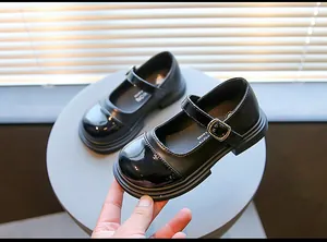 Detailed macro shot of girls black Mary Jane shoes with patent leather toe and buckle strap
