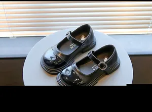 Gros plan de chaussures Mary Jane noires pour filles en cuir verni brillant élégant