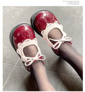 Primer plano de zapatos Mary Jane granates para niña con encaje blanco y detalle de lazo