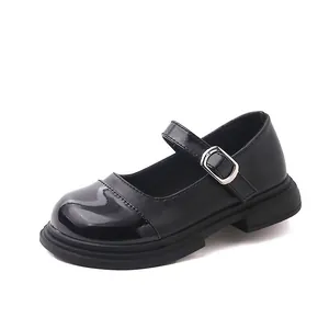 Gros plan de chaussures Mary Jane bicolores noires pour filles avec boucle argentée.
