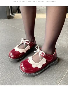 Detalle de los zapatos Mary Jane de charol granate para niña con encaje blanco y lazo.