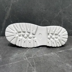 Detail view of white chunky lug sole for men's high-top sneakers with tread pattern.