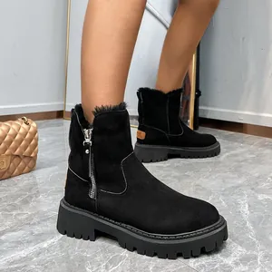 Close-up detail of stylish black suede snow boots featuring a side zipper and thick lug sole