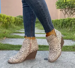 Primer plano de botines de cuña con estampado de leopardo vintage con cremallera