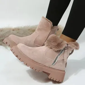 Close-up view of stylish pink faux fur-lined snow boots with chunky lug soles for winter.