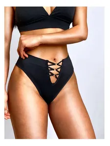 Vue détaillée d'un string noir sexy à taille haute avec un design de lacets à anneaux dorés
