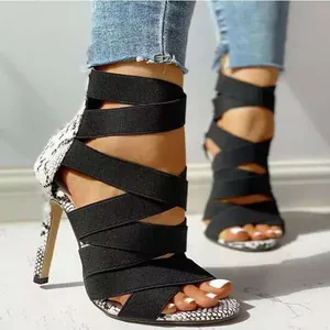 Close-up view of elegant black elastic strap high-heel sandals featuring snakeskin accents
