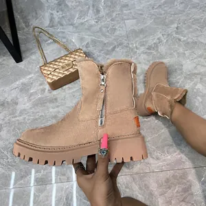 Close-up of tan suede snow boots with side zipper and thick platform sole
