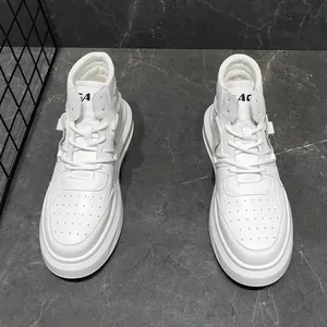 Top-down view of stylish white mid-top sneakers with thick soles on marble background.