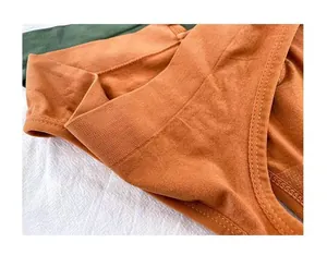 Gros plan du string sans couture orange montrant la texture en maille respirante.