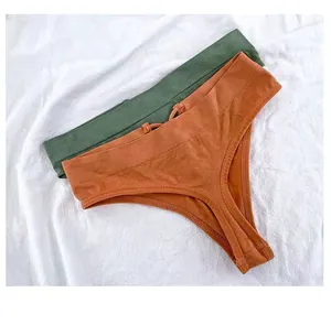 Deux tangas sans couture à taille haute en vert et orange sur un fond de tissu blanc.