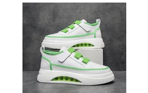 Detail of white and green men's sneakers with velcro straps and thick air cushion sole