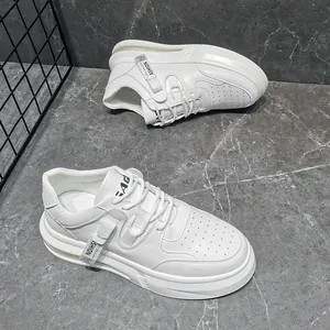 Detailed top view of white mid-top sneakers with fashion tags and marble floor background