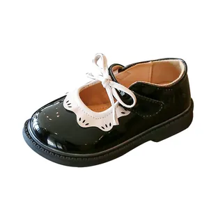 Elegantes zapatos de charol negro para niña con ribete de encaje blanco y un lazo