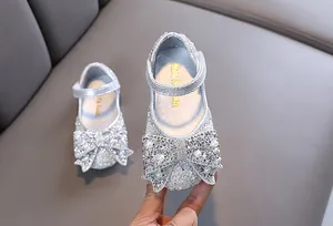 Detailopname van zilveren prinsessenschoenen voor meisjes met een grote strik