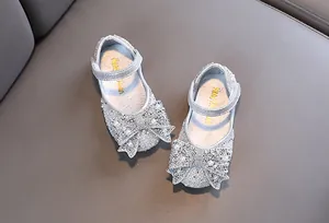 Detail van zilveren prinsessenschoenen voor meisjes met een grote strik van strass
