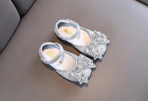 Gedetailleerd overzicht van zilveren glitter prinsessenschoenen met parelmoeren strik