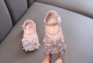 Detailoverzicht van roze prinsessenschoenen voor meisjes met stras en grote strik