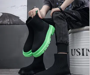 Close-up detail of men's high-top knitted sock shoes with vibrant green thick soles