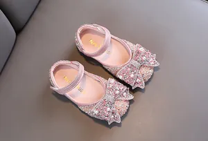 Detailopname van roze glitter prinsessenschoenen voor meisjes met grote strass strik