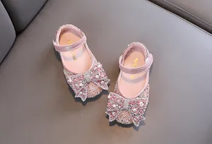 Detail van roze prinsessenschoenen voor meisjes met fonkelende strikken van strass