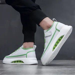 Stylish white and green men's sneakers with visible air cushion sole on model side view