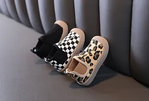 Detailed view of kids mid-top canvas shoes in black, checkered, and leopard print