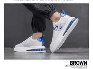 Close-up of stylish white men's slip-on sneakers with elastic strap and blue air cushion