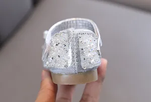 Detail van een zilveren prinsessenschoen voor meisjes met strassteentjes en parels