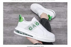 Close-up view of white men's casual slip-on sneakers featuring a green elastic strap