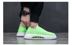 Dettaglio ravvicinato di sneaker a calzino in flyknit verde neon da uomo con suola bianca