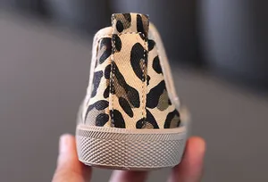 Close-up view showing the leopard print fabric and thick rubber sole of a boys canvas shoe