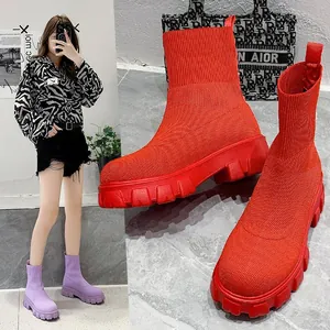 Detailed close-up of vibrant red knitted platform sock boots featuring chunky rugged soles