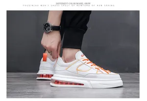 Detalle de zapatillas de moda blancas para hombre con cordones naranjas y cámara de aire