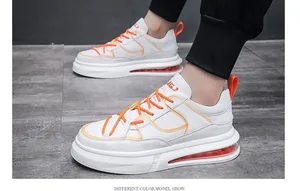Vista lateral de zapatillas blancas de hombre con cámara de aire y cordones naranja