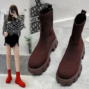 Detail view of fashionable brown knit sock boots with thick lug sole and high-top