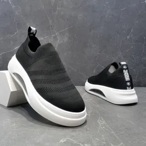 Primo piano delle sneaker da uomo in maglia nera traspirante con suole bianche spesse ed eleganti