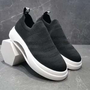 Dettaglio di scarpe da ginnastica a calza in maglia nera traspirante con suola platform bianca.