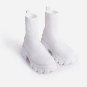 Detailed side view of white knitted high-top sock boots featuring a thick chunky platform sole