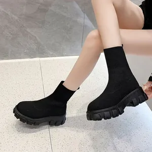 Women's black knitted sock boots with a thick lug sole and high-top platform design.