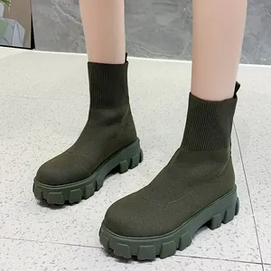 Detailed side view of trendy army green knitted sock boots with thick lug soles for women