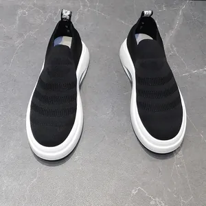 Vista dall'alto di sneaker a calzino in maglia nera traspirante con suole bianche spesse