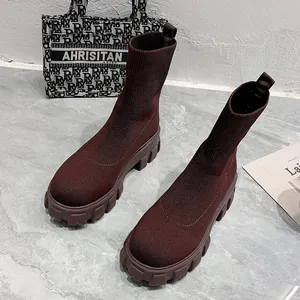 Close-up of stylish burgundy knit sock boots with thick platform lug soles