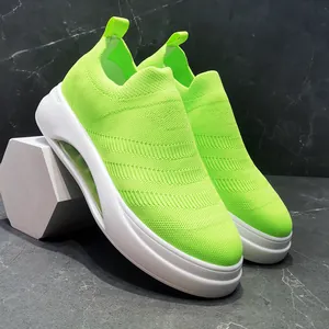 Vista laterale dettagliata di sneaker in maglia verde neon con spesse suole bianche gommate.